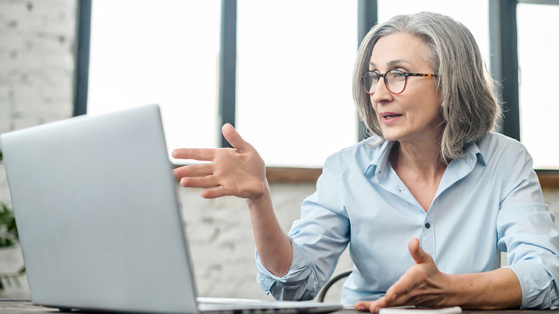A woman talks in a video call using her laptop