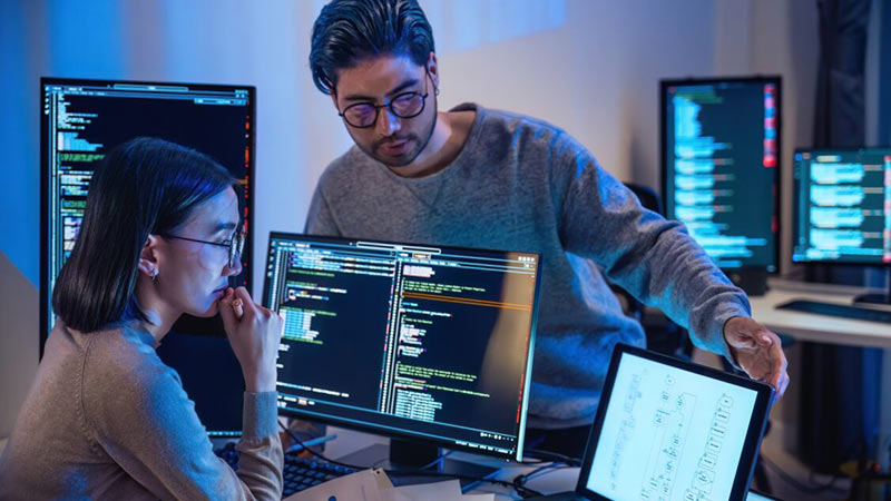 Three employees reviewing it security assesments on a desktop