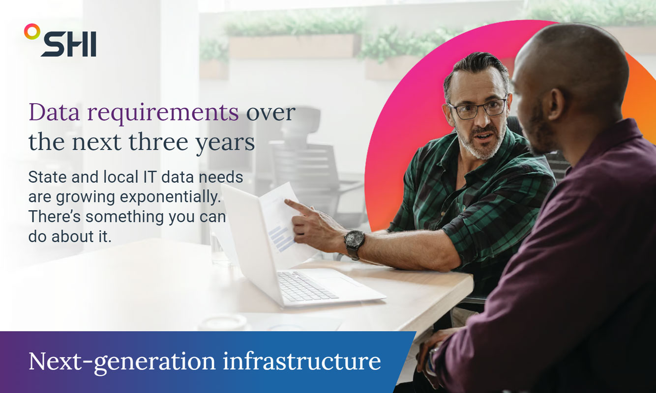 Man points at data report while talking to another man with the SHI Halo behind them