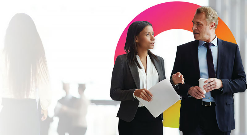 A man and woman in business attire have a discussion holding papers