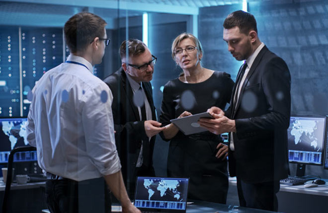 individuals gathered around a tablet in a data center