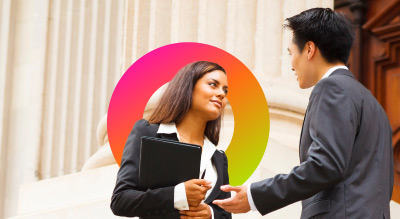 A business handshake in front of a government building