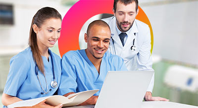 Three people in medical attire working on a laptop