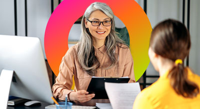 Two professional individuals are engaged in a discussion at a desk