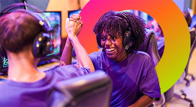 Students high five each other while using handheld esports devices