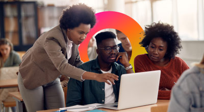 Teacher and two student looking over laptop