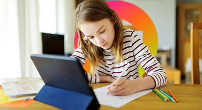 Girl doing school work with tablet in front of her