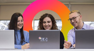 three coworkers in front of laptops
