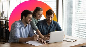 three people in front of a laptop