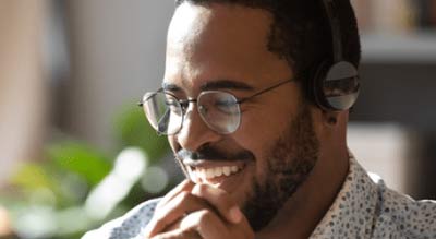 Man sitting infront of computer with headphones on