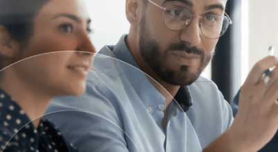 Man and woman listen in an office meeting