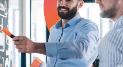 Man in conference room pointing to whiteboard