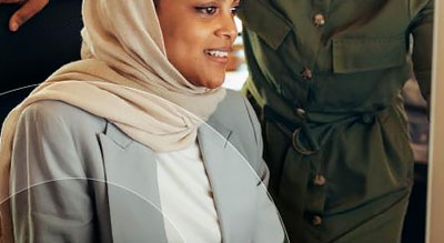 A person smiles looking at a desktop monitor