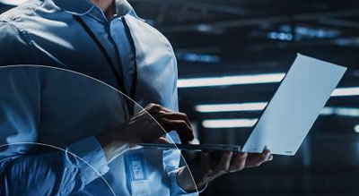 Man uses laptop while standing in data center