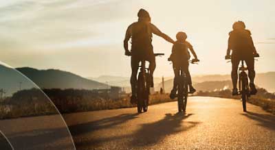 Three people ride bicycles on a road