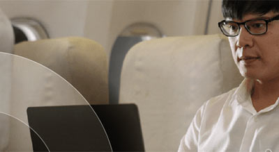 Man uses laptop on airplane