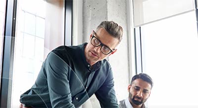 Man in meeting leans on table