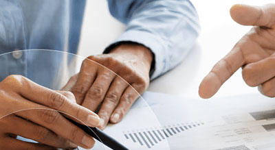 A person reviews a data sheet with a pen in hand