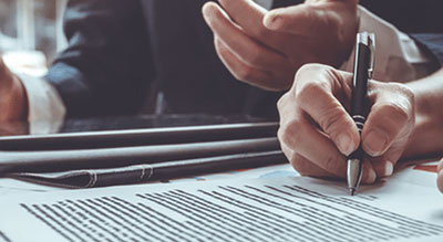 Close up of a hand signing some documents