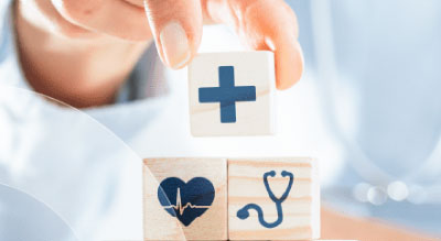 Hand stacks wooden blocks with medical related symbols