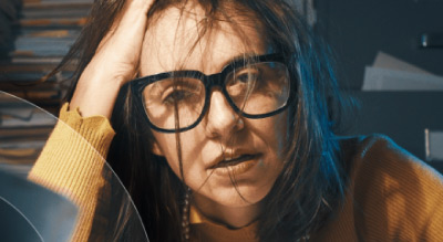 Exhausted woman surrounded by stacks of paperwork