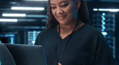 Woman on laptop in server room