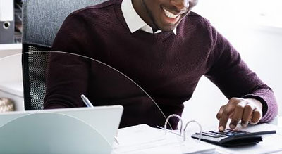 Man uses calculator while writing in binder