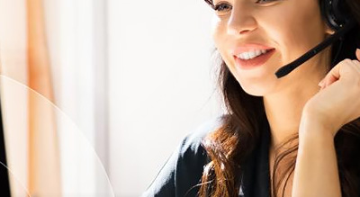 a smiling woman wears a headset