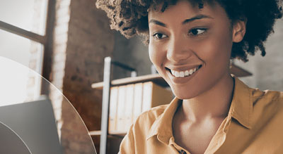 Smiling woman uses laptop at desk