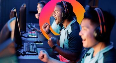 Adult gamers sitting infront of computers with headsets on