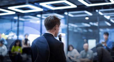 Man speaking on microphone in front of people