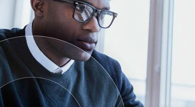 Chest up shot African American man with glasses looking down to the right