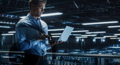 Man working on laptop at data center