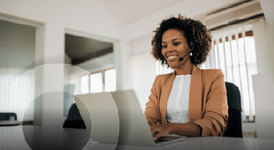 Woman in an office on laptop with headset