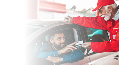 Man in car at gas station with gas attendant