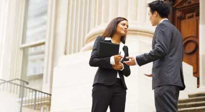 man and woman talking infront of court house