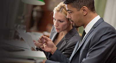 man and woman look over document