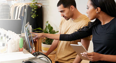 Manager points at monitor training an employee