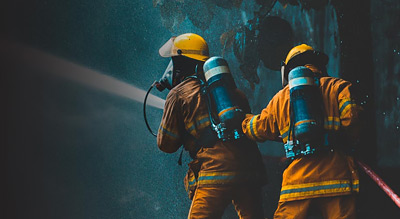 Two firefighters enter a burning building