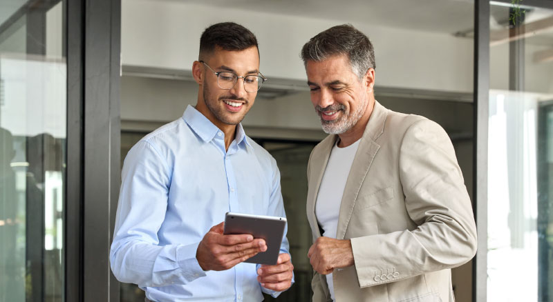 Two individuals looking over a tablet together