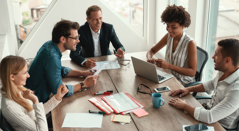 A group of individuals seated around a table having a meeting in office space