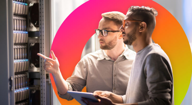 Two individuals discussing server configurations in front of a server rack