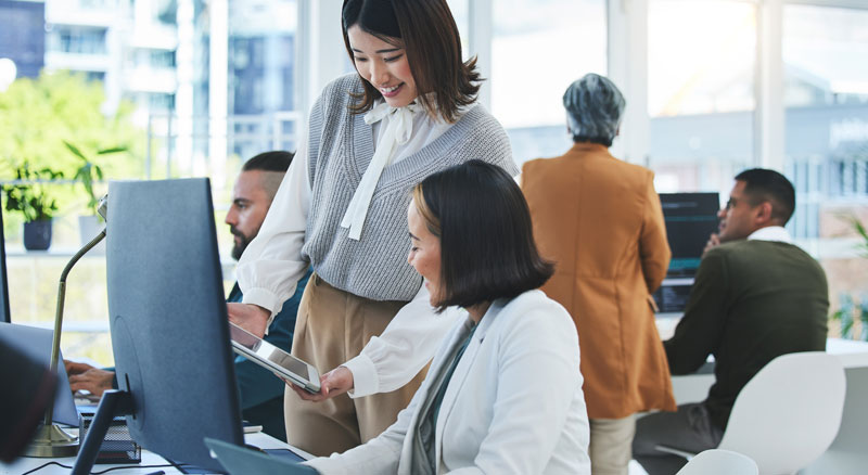 A group of professionals collaboratively engage in discussions, brainstorming ideas, and working on a shared project in an office environment