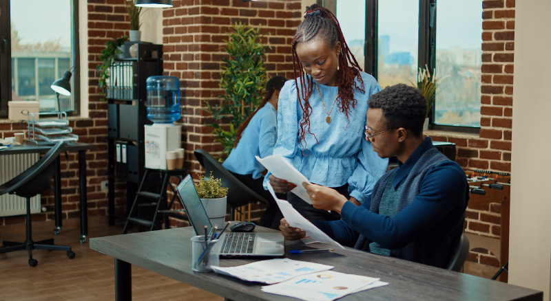 Two people reviewing documents in a modern office