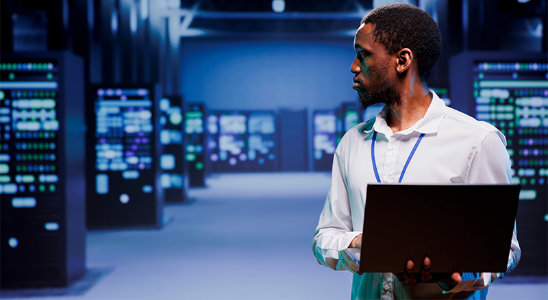 Person on computer in large server room