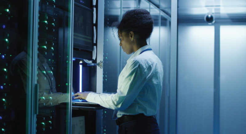 Woman on computer in server room