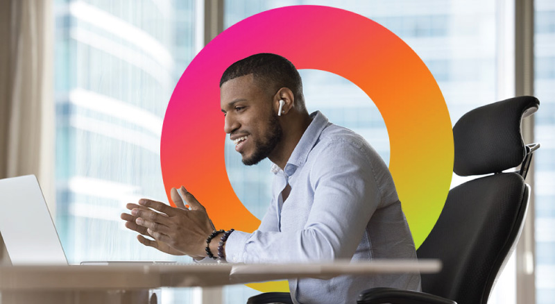 A man sitting at a desk, focused on a laptop 