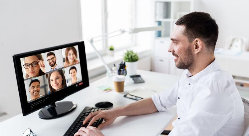 Man working from home video chatting with his coworkers