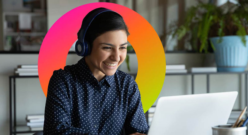 Smiling woman wearing headset uses laptop