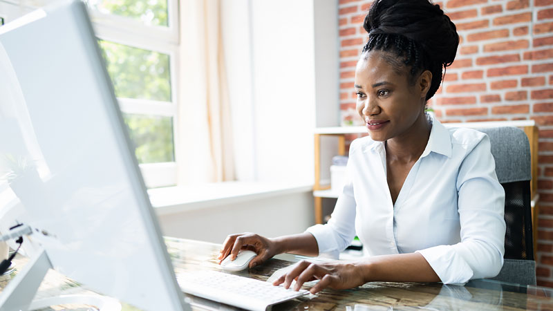 Woman uses desktop computer at home office